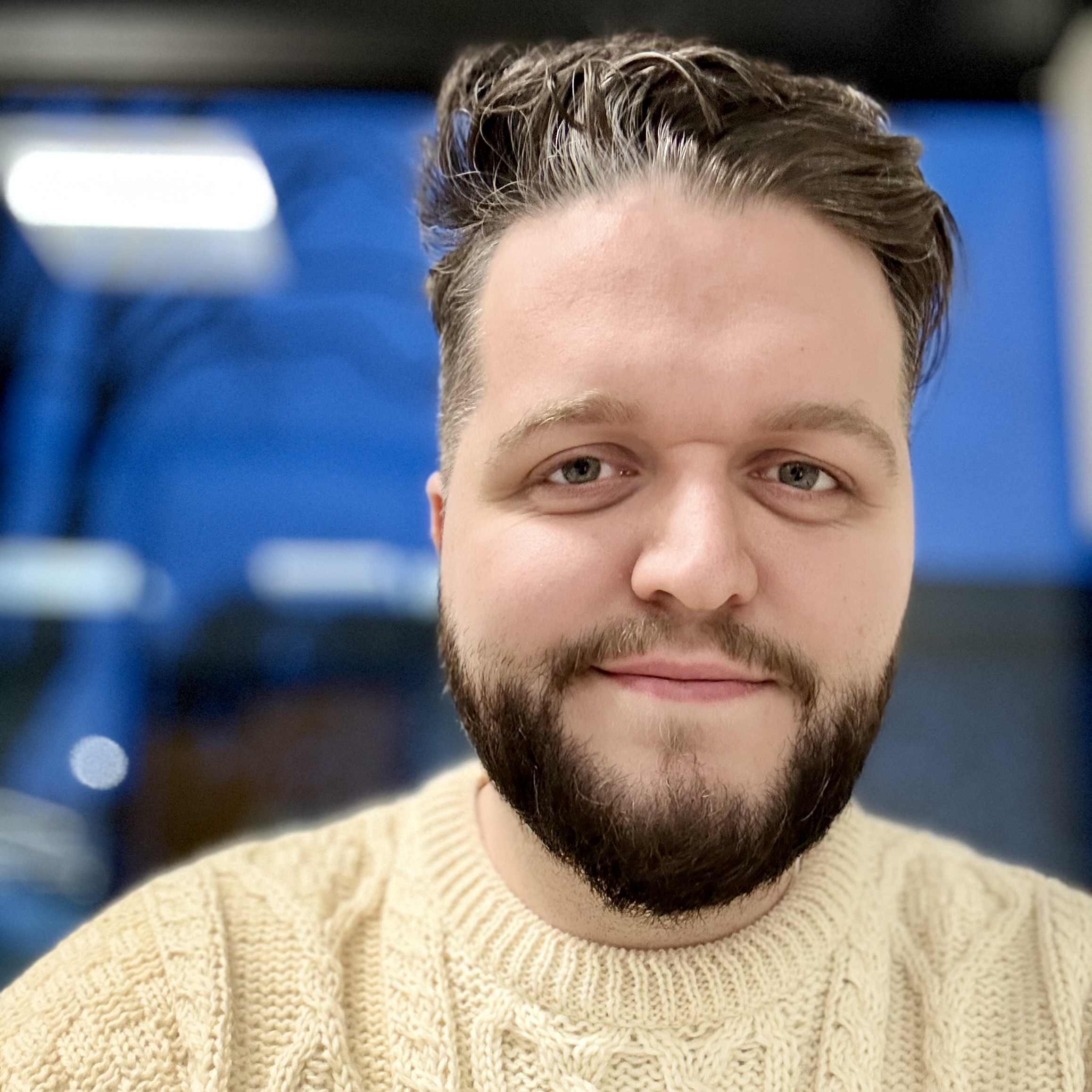 Selfie in a cable knit sweater with an evening blue sky out the window in the background.