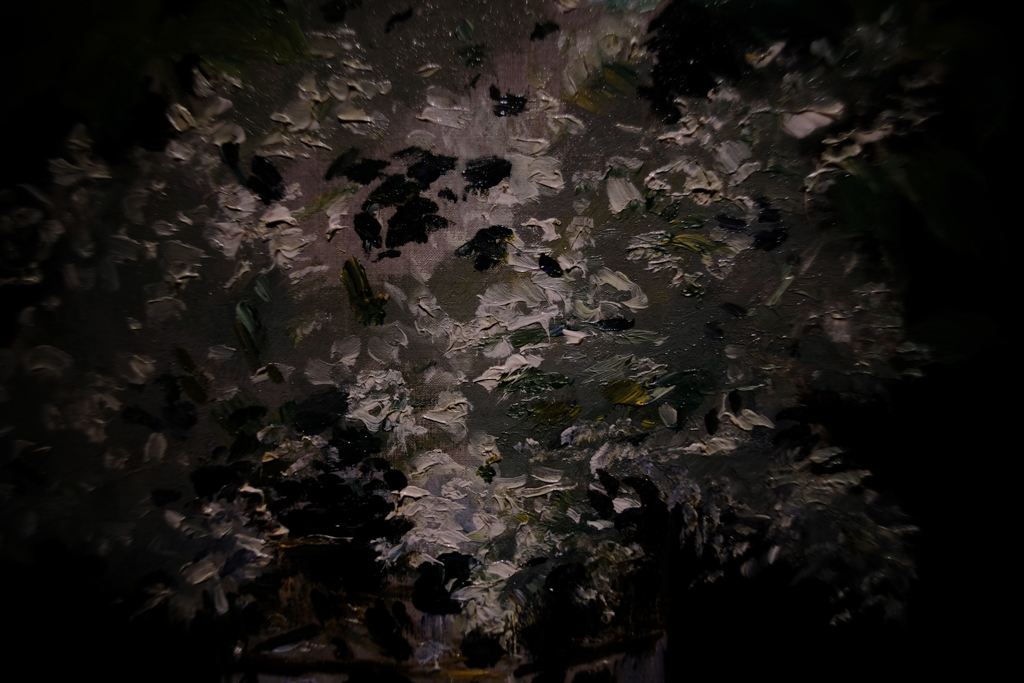 Close-up of impressionist paint marks of white on a dark grey background.